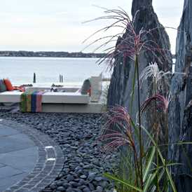 Skifer skulpturer på terrasse med lounge designet af havearkitekt Tor Haddeland